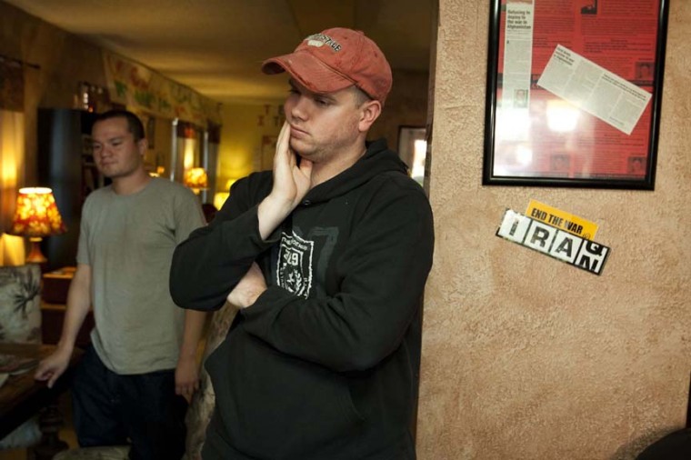 Former soldiers watch news about mass shooting
